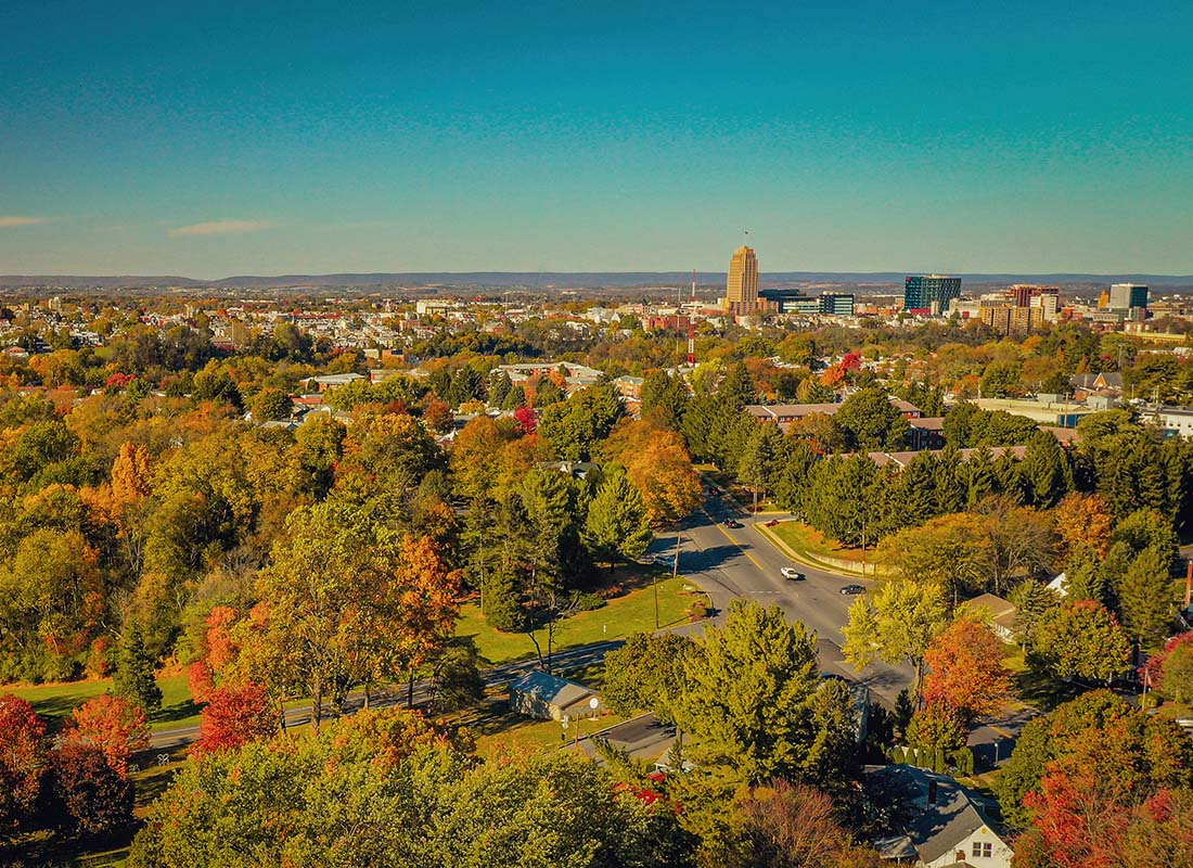 Allentown, PA - Aerial View of Homes Surrounded by Colorful Fall Trees with the Downtown City Area of Allentown Pennsylvania Visible in the Distance